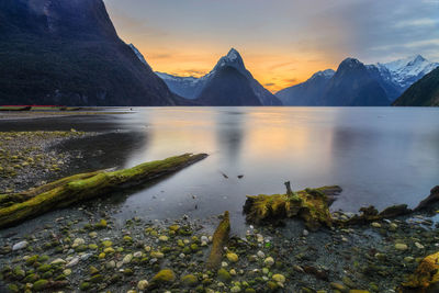 Scenic view of lake and mountains against sky during sunset