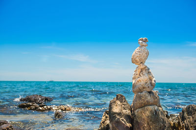 Zen stones balance at stony beach and sea background