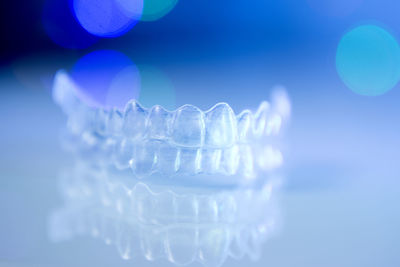 Close-up of dental aligner against blue background