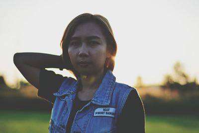 Portrait of young woman standing against sky