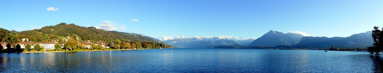 Panoramic view of sea and mountains against blue sky