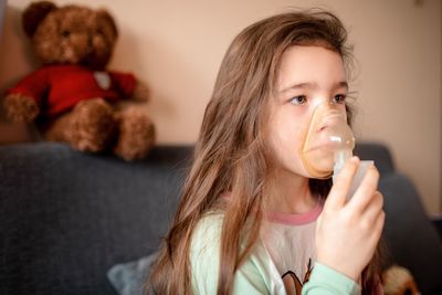 Portrait of girl drinking from toy at home