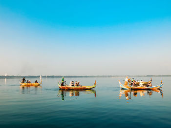 Boats in sea against clear sky