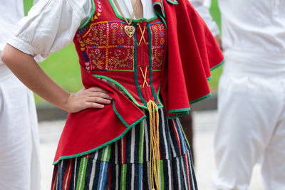 Midsection of woman standing with red umbrella