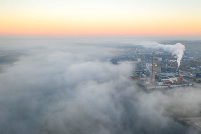 Aerial view of industry emitting smoke against sky