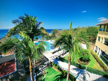 High angle view of palm trees by swimming pool against sky