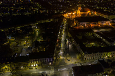 High angle view of illuminated street amidst buildings at night