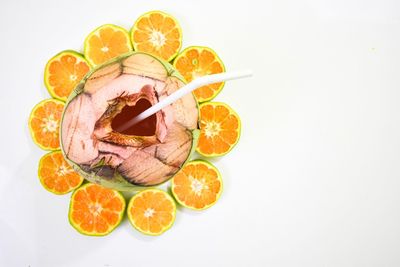 High angle view of orange fruit against white background