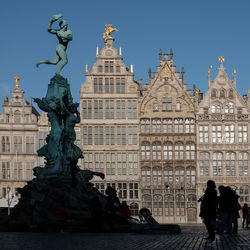 Statue of brabo on the grote markt square of antwerp  against blue sky