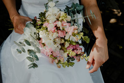 Midsection of bride holding bouquet