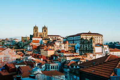 Buildings in city against clear sky