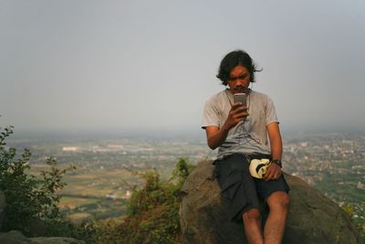 Full length of young man standing against clear sky