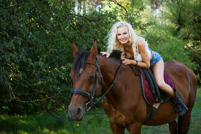 Beautiful woman with horse in summer park