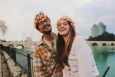 Portrait of smiling friends standing by railing
