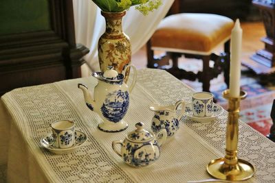 High angle view of teapots and cups on table