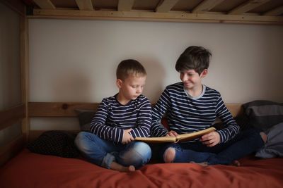 The brothers read together on two bunk beds in the nursery, the concept of kinship and childhood, 