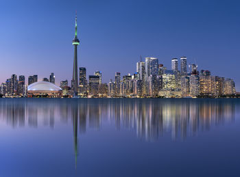 Reflection of buildings in city at waterfront