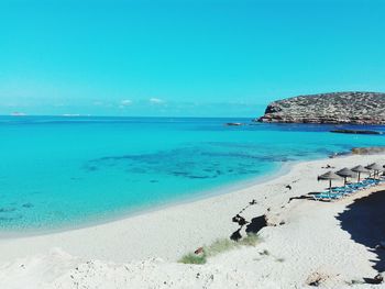 Calm beach against blue sky