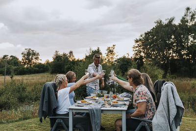 Rear view of people sitting on table