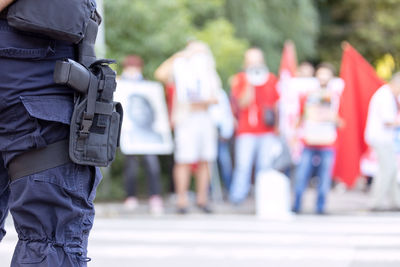 Policeman on duty during street protest, blurred protesters in the background