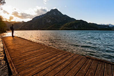 Scenic view of lake by mountains against sky