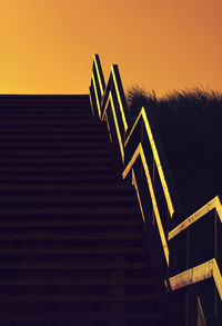 Low angle view of staircase against sky during sunset