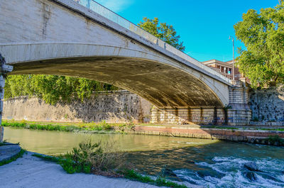 Arch bridge over river against sky