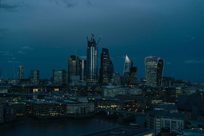 Illuminated buildings against sky in city at dusk