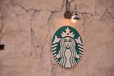 Close-up of light bulb hanging against wall