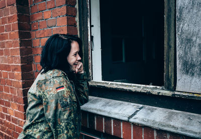 Close-up of woman by the window of building