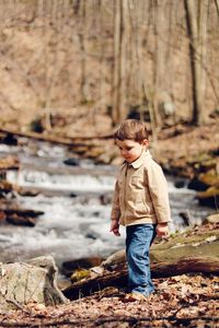 Full length of boy standing in forest