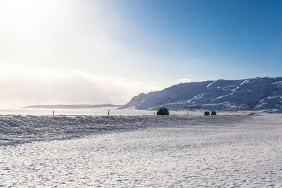 Scenic view of snowcapped mountains by sea against sky