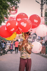 A kid selling balloons with a happy face