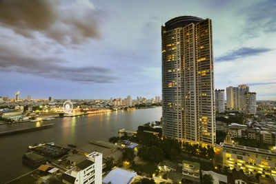 Aerial view of buildings against cloudy sky