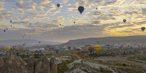 Hot air balloons flying against sky during sunset