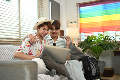 Young woman using laptop while sitting on sofa at home