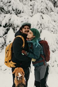 Couple in love with dog on snow