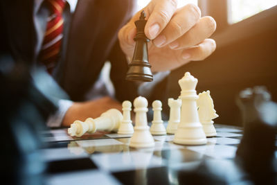 Midsection of businessman playing chess