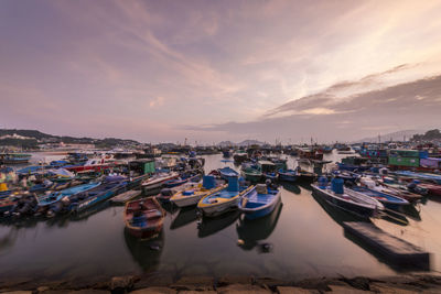 Boats in harbor at sunset