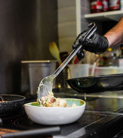 Cropped hand of man preparing food in kitchen