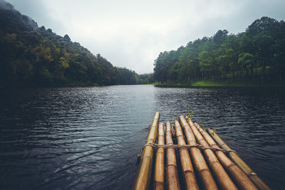 Scenic view of wooden raft in lake against sky