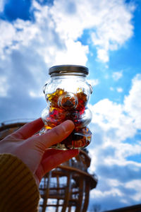 Person holding ice cream against sky