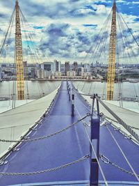 View of suspension bridge against cloudy sky