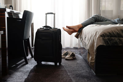 Woman taking off footwear in a hotel room on the bed. tourist relaxing on hotel room after
