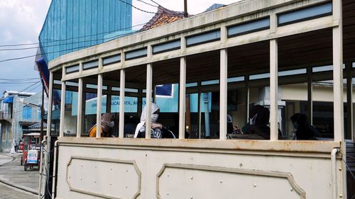 People waiting in city against sky