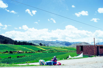 Man lying on mountain against sky