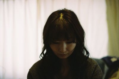 Portrait of young woman looking away at home