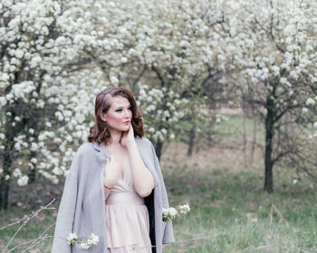 Beautiful girl in a dress walking in a blooming garden