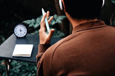 Rear view of man using mobile phone