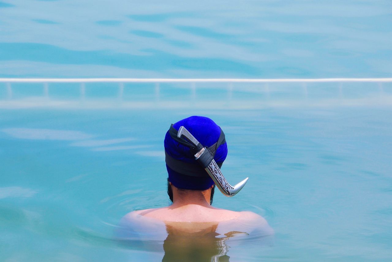 water, leisure activity, lifestyles, real people, day, one person, blue, sea, nature, rear view, men, sport, hat, outdoors, clothing, motion, cap, trip, swimming pool